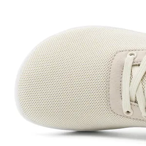 Gros plan détaillé montrant la texture fly-knit respirante et le bout large du pied.
