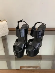 Detailed macro view of glossy black patent leather platform sandals with chunky high heels
