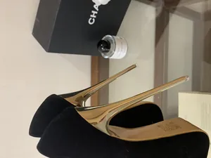 Close-up of gold metal stiletto heel on black platform pump shoe