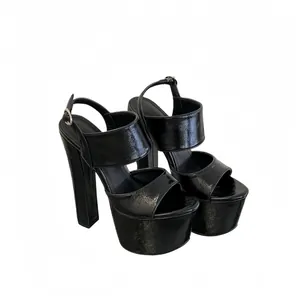 Professional close-up of black patent leather platform sandals with chunky high heels