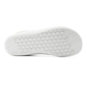 Gros plan détaillé montrant les motifs hexagonaux et ondulés antidérapants de la semelle blanche.