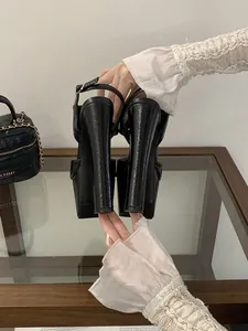 Detailed back view showing extreme high thick heels of black glossy platform sandals.