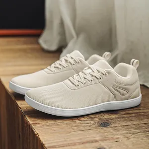 Gros plan de baskets pieds nus beiges à bout large avec maille respirante sur bois