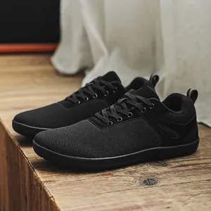 Vue latérale de chaussures pieds nus noires en flyknit avec design à boîte à orteils.