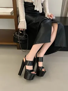 Close-up of elegant black high-heel platform sandals worn by a model sitting down