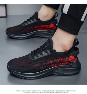 Close-up of black and red breathable fly-knit sneakers on a model for casual wear