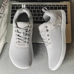 Baskets de style pieds nus gris clair avec pointe large et tige en mesh flyknit.