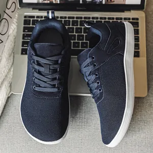 Vue détaillée des baskets pieds nus bleu marine à bout large posées sur un ordinateur