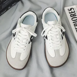 Vista dall'alto di sneakers casual bianche e grigie con punta larga su tessuto