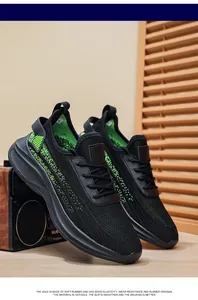Detailed shot of breathable black knit men's sneakers with green accents and soft sole