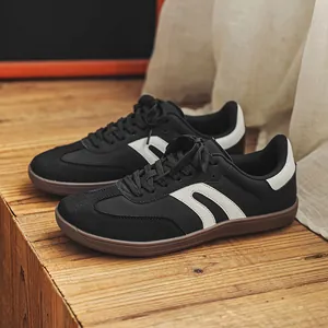 Vista dettagliata di sneaker in pelle nera stile GAT con strisce bianche su legno.