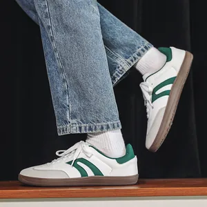Dettaglio scarpe GAT in pelle bianca con strisce verdi e suola in gomma marrone