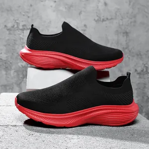 Close-up detail of breathable black fly-knit men's sneakers featuring chunky red soles