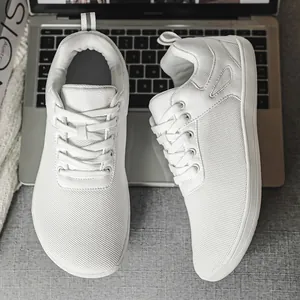 Gros plan de chaussures pieds nus blanches à bout large montrant la texture en maille