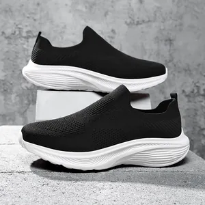 Close-up detail of breathable black fly-knit men's slip-on sneakers with white soles