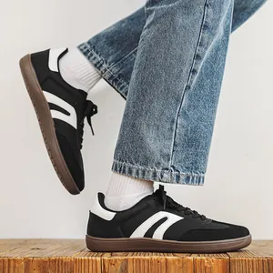 Dettaglio di scarpe da ginnastica tedesche in pelle nera con calzata ampia su legno