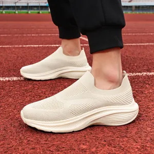 Detail showing the breathable knit texture of beige slip-on walking shoes on a track.