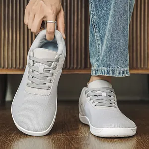 Gros plan sur des chaussures minimalistes grises à bout large en maille respirante.
