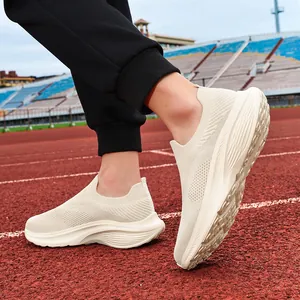 Detailed view of men's off-white breathable knit slip-on walking shoes on a track