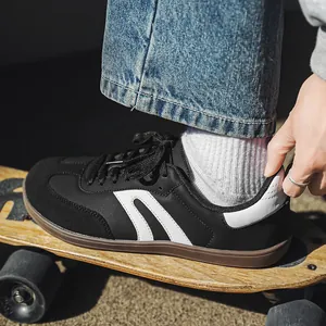 Dettaglio di scarpe da ginnastica tedesche nere con striscia bianca su uno skateboard