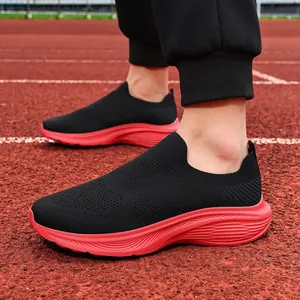 Close-up of breathable black and red slip-on mesh sneakers on a running track