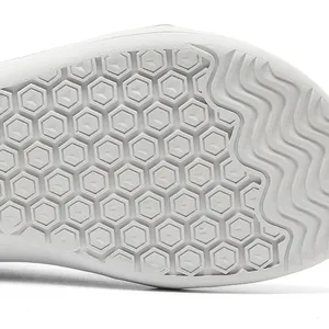 Detailed macro view of the non-slip white rubber sole of an ergonomic barefoot shoe
