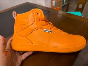 Nahaufnahme der leuchtend orangefarbenen High-Top-Winterstiefel mit breitem Zehenbereich