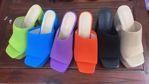 Array of colorful knitted platform sandals with chunky heels and square toes.