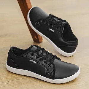 Detailed view of black leather barefoot sneakers on a wooden floor with a white sole
