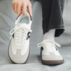 Dettaglio delle sneaker German Trainer a punta larga in pelle bianca e camoscio.