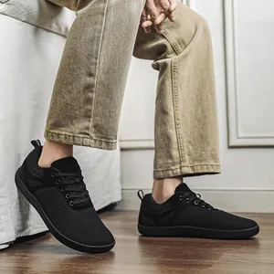 Détail de chaussures pieds nus en flyknit noir avec boîte à orteils large et semelle zéro