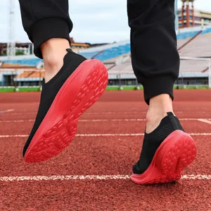 Detailed view of men's breathable black mesh slip-on sneakers with thick red soles