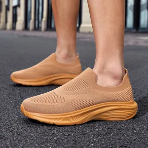 Detail of men's breathable camel fly-knit slip-on sneakers in lifestyle setting
