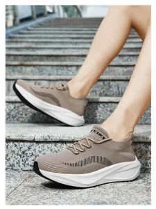 Nahaufnahme von Fly-Knit-Laufschuhen mit dicken Sohlen auf steinernen Außentreppen