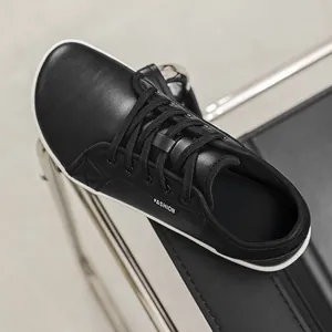 Close-up of black leather wide-toe barefoot shoe with lace-up minimalist design