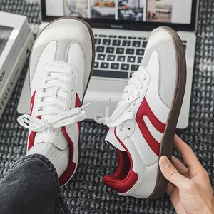 Primo piano dettagliato delle scarpe German Army Trainers in pelle bianca con strisce rosse