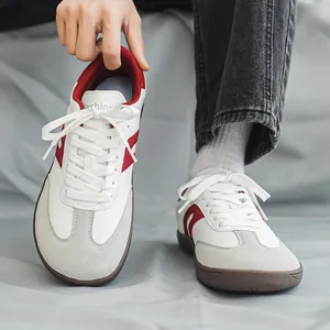 Close-up of wide-toe German army trainers with red stripes and gum sole