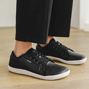 Detailed shot of black leather wide-toe barefoot shoes featuring a lace-up design and flat sole.