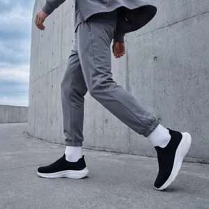 Breathable men's wide-toe slip-on sneakers shown in a walking motion outdoors.