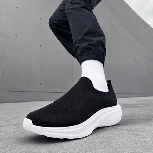 Close-up of black breathable fly-knit slip-on sneakers for men with white thick sole