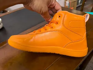 Detaillierte Seitenansicht eines leuchtend orangefarbenen High-Top-Schneeschuhs.