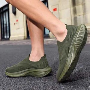 Side view of olive green breathable knitted slip-on sneakers for men on a model