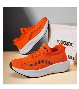 Seitenansicht der leuchtend orangefarbenen Strick-Laufschuhe mit dicker weißer Sohle.