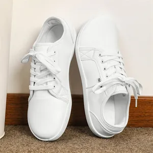 Detailed view of minimalist white leather barefoot shoes with comfortable wide toe design