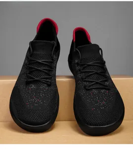 Detailed front view of lightweight black fly-knit men's sports sneakers with red accents