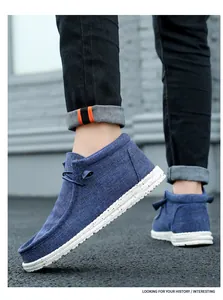 Close-up detail of blue high-top canvas loafers showing the textured fabric and speckled sole
