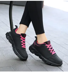 Vista laterale dettagliata delle sneaker nere da donna con vivaci lacci e finiture rosa.