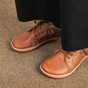 Macro view of brown leather wide-toe barefoot shoes featuring classic lacing and soft flat soles