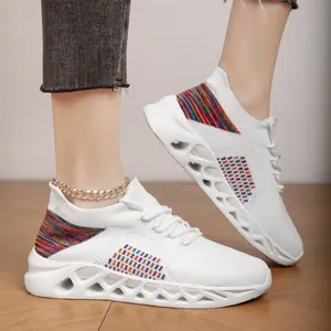 Close-up of breathable white fly-knit sneakers with rainbow accents and hollowed sole