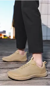 Close-up of tan minimalist barefoot hiking shoes worn on a textured wooden walkway